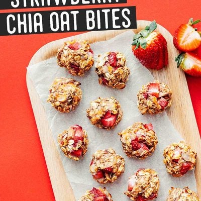 Strawberry oat cookies on a wooden plate with a red background