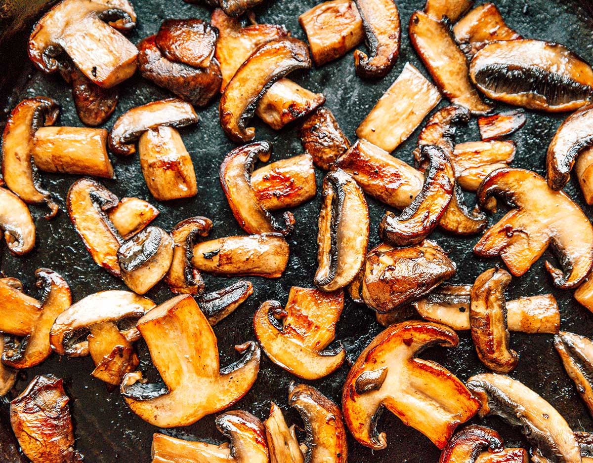 A saute pan filled with sliced mushrooms