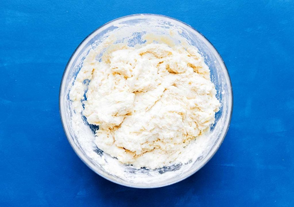 Mixed dough in a bowl on a blue background