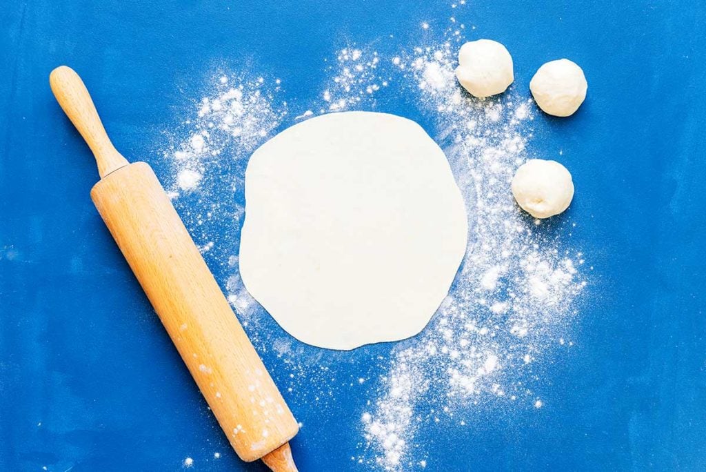 Rolling out tortillas on a blue background