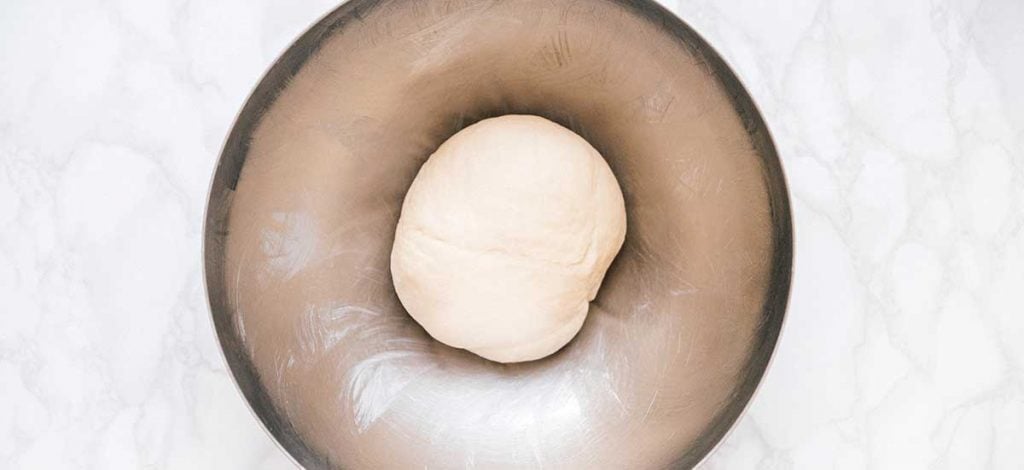 Kneaded dough in a metal bowl