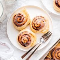 Cinnamon rolls with icing on a plate with marble background