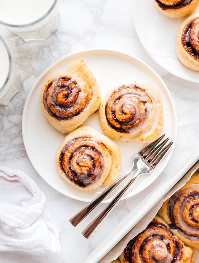 Cinnamon rolls with icing on a plate with marble background