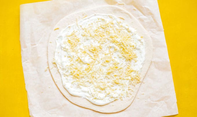Making goat cheese pizza on parchment paper