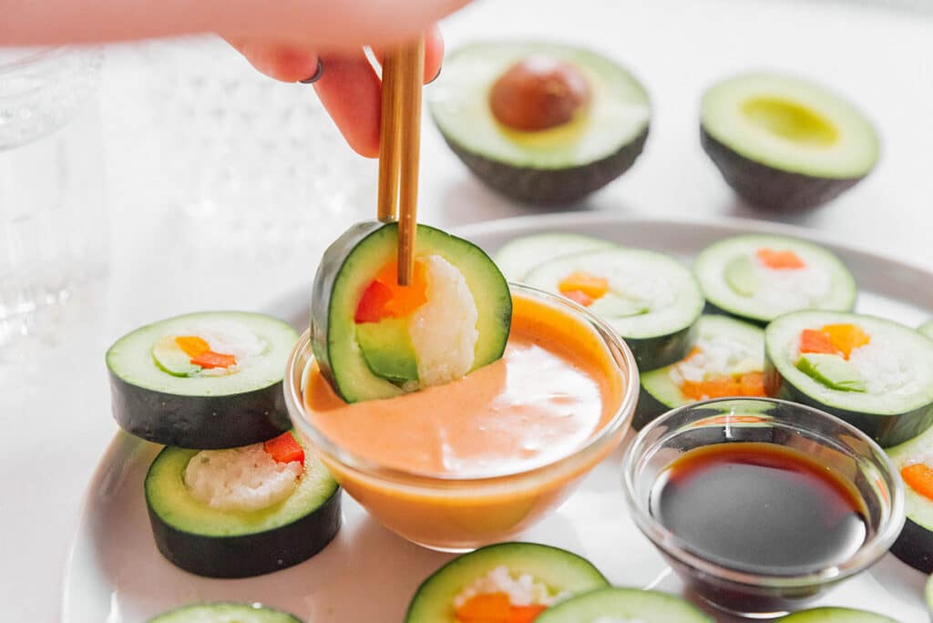 Dipping stuffed cucumber into spicy mayo