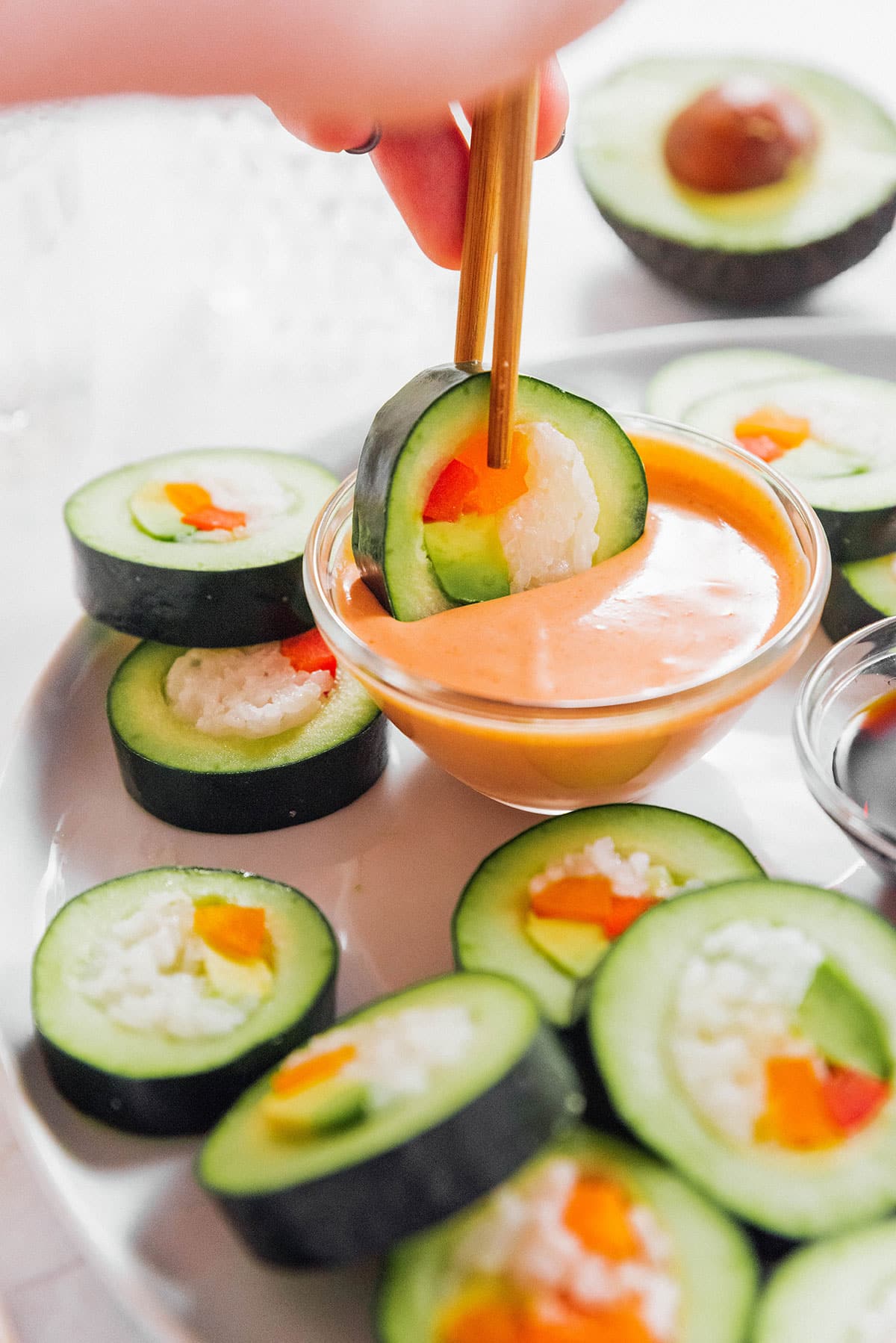 Dipping stuffed cucumber into spicy mayo