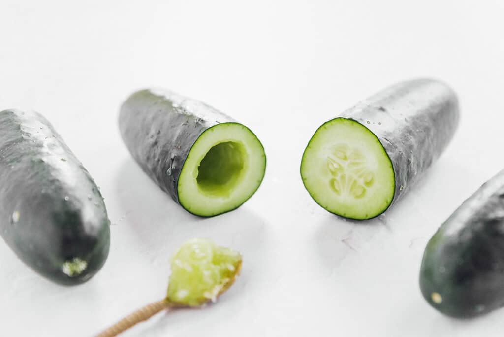 Scooping the inside out of a cucumber