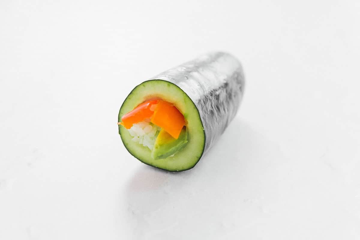 Stuffing a cucumber with rice and carrots