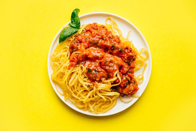 Chunky fresh marinara sauce on a plate of spaghetti