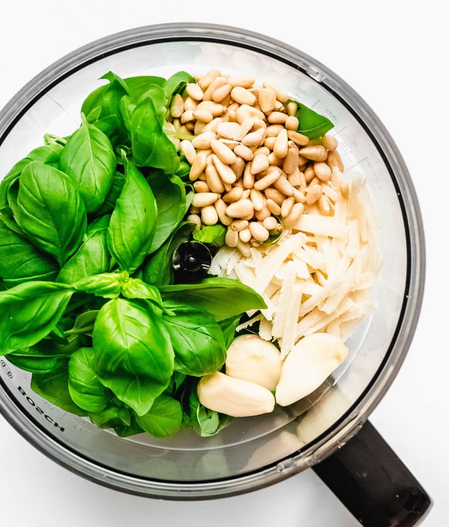 Ingredients to make pesto in a food processor