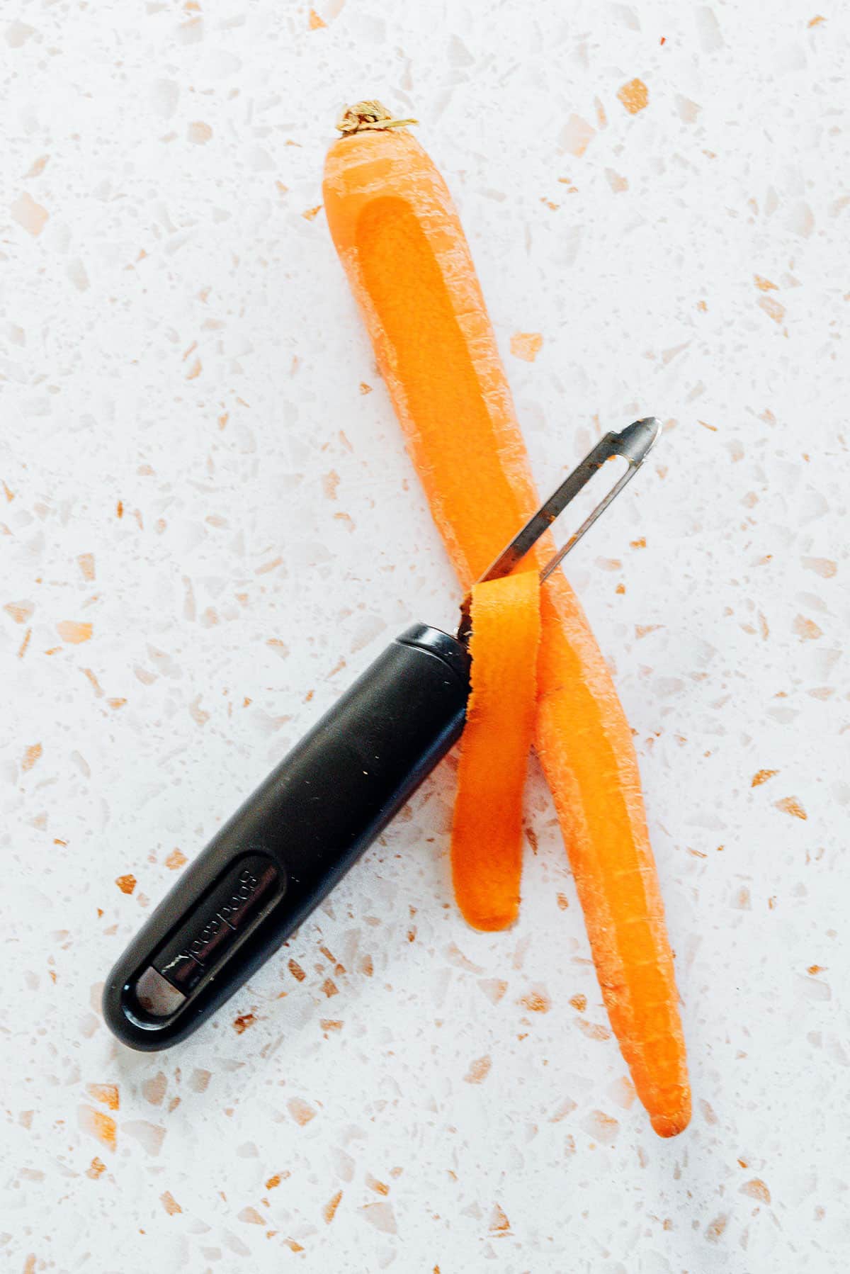 Shaving carrot noodles with a vegetable peeler
