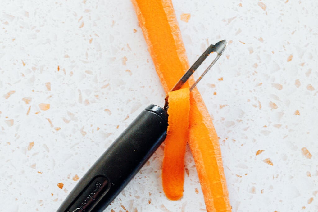 Making carrot noodles with a peeler.