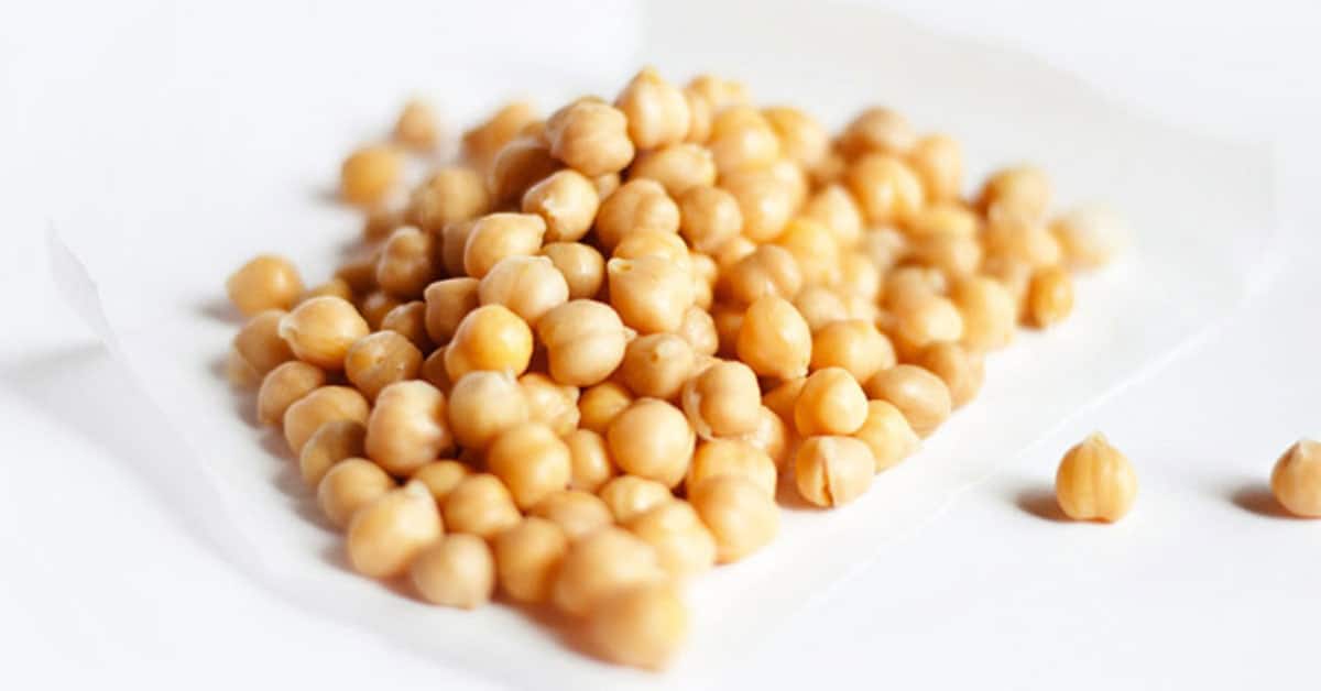 Chickpeas on a white parchment paper on an isolated white background.