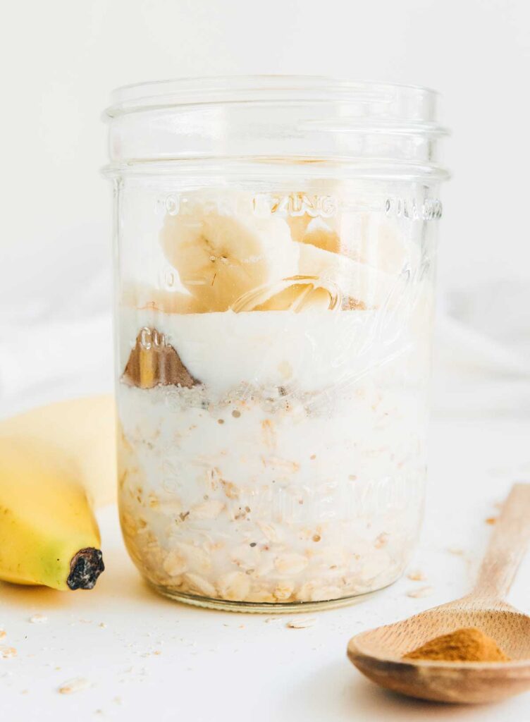 A mason jar filled with banana bread overnight oats ingredients