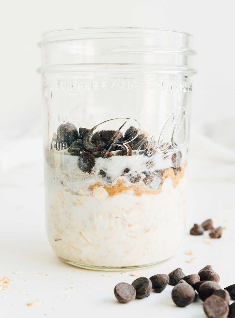 A mason jar filled with cookie dough overnight oats ingredients