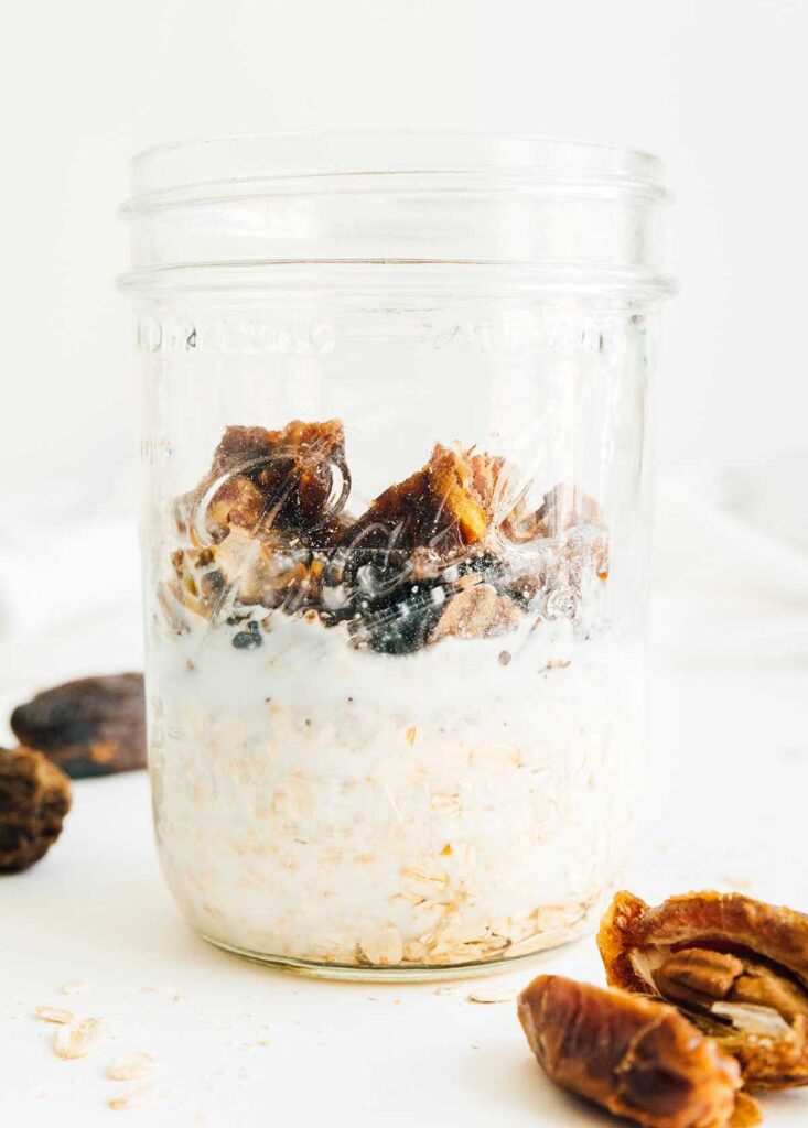 A mason jar filled with salted caramel overnight oats ingredients