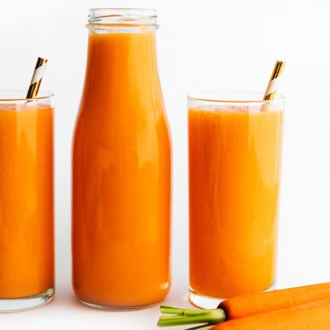 Carrot juice in a glass on a white background