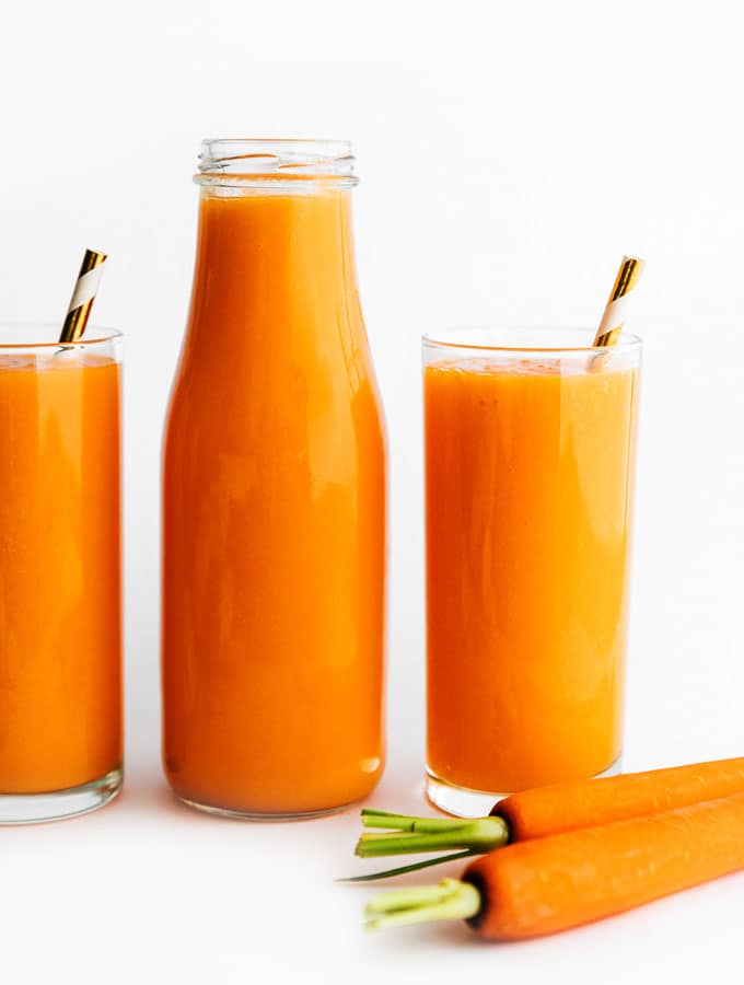 Carrot juice in a glass on a white background
