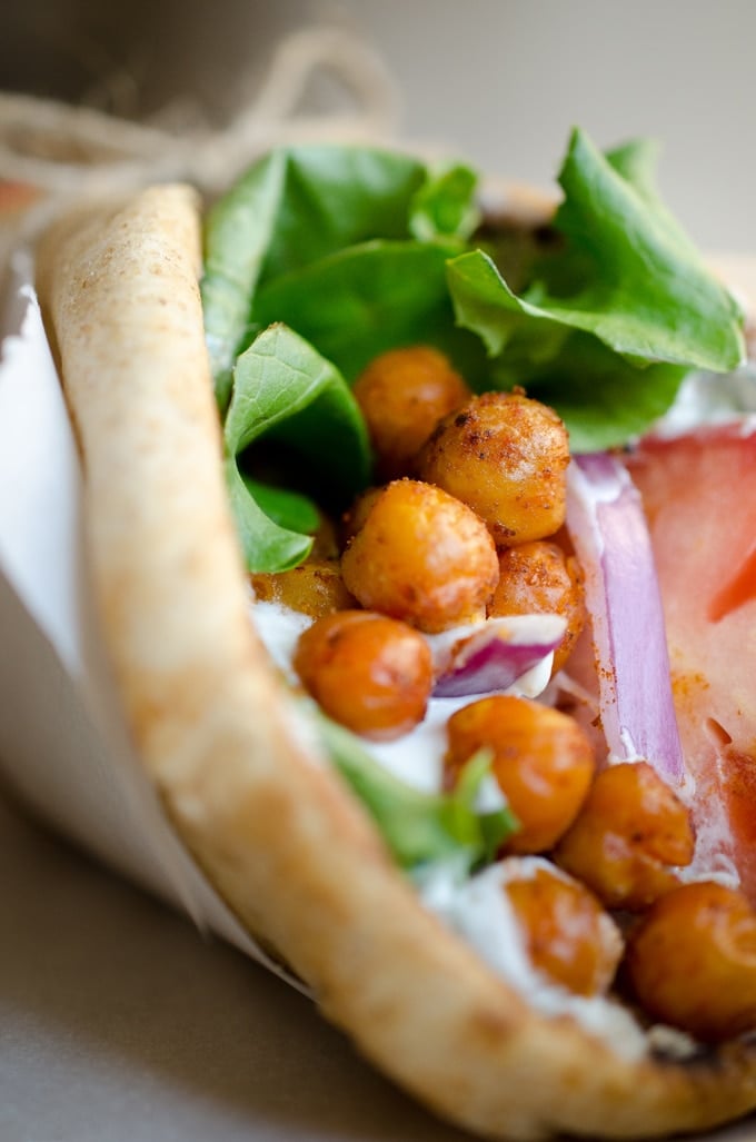 Close up photo of roasted chickpea gyros with tomato and lettuce in a pita wrap