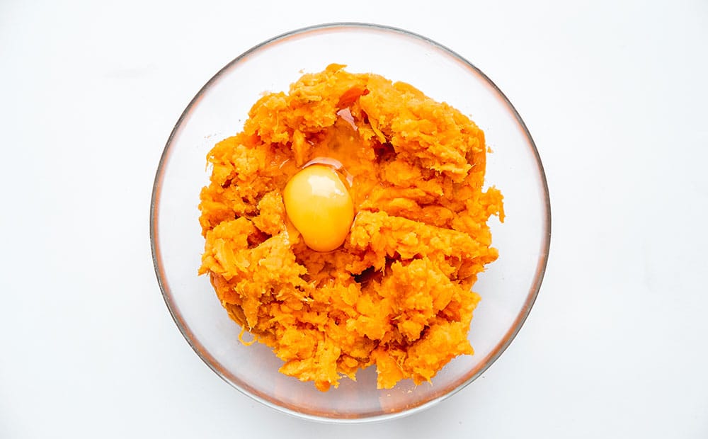 Mashed sweet potato and egg in a bowl