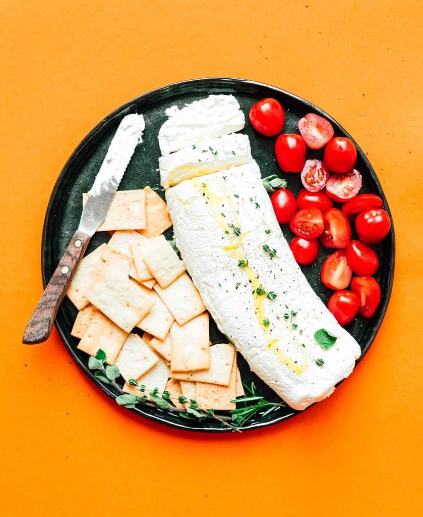 Greek yogurt cheese on a plate with crackers and tomatoes