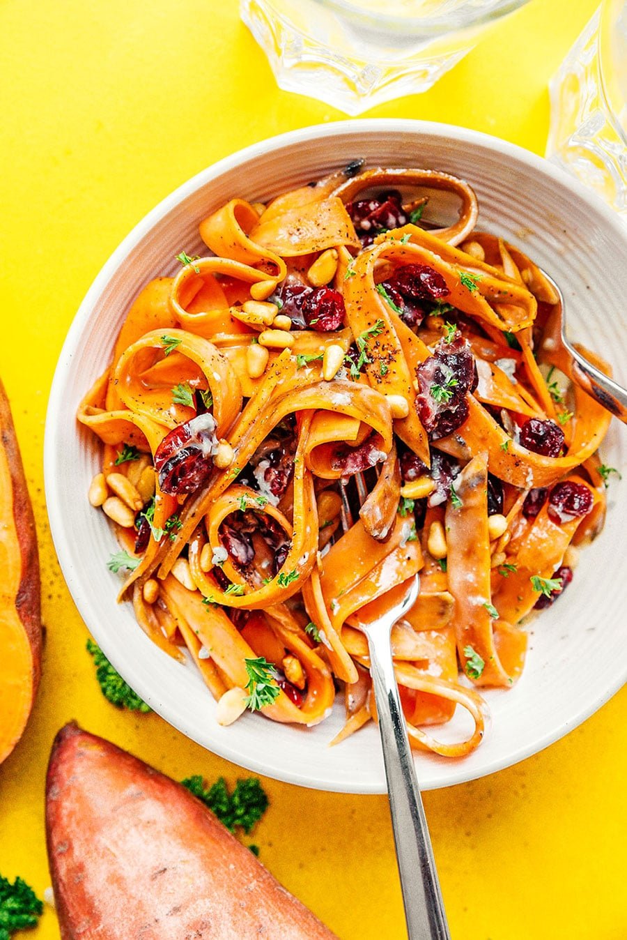 Sweet potato fettuccine noodles in a bowl on a yellow background