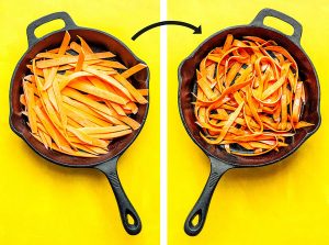 Sweet potato fettuccine noodles in a cast iron skillet on a yellow background