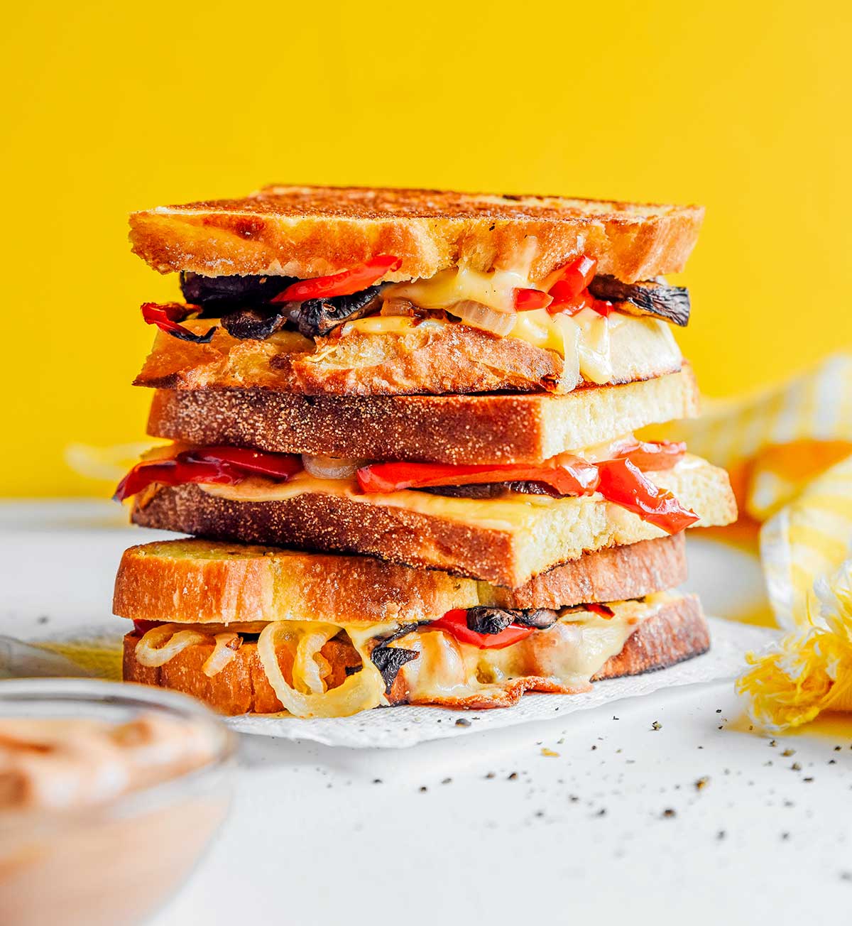 Three roasted vegetable grilled cheeses stacked on top of one another