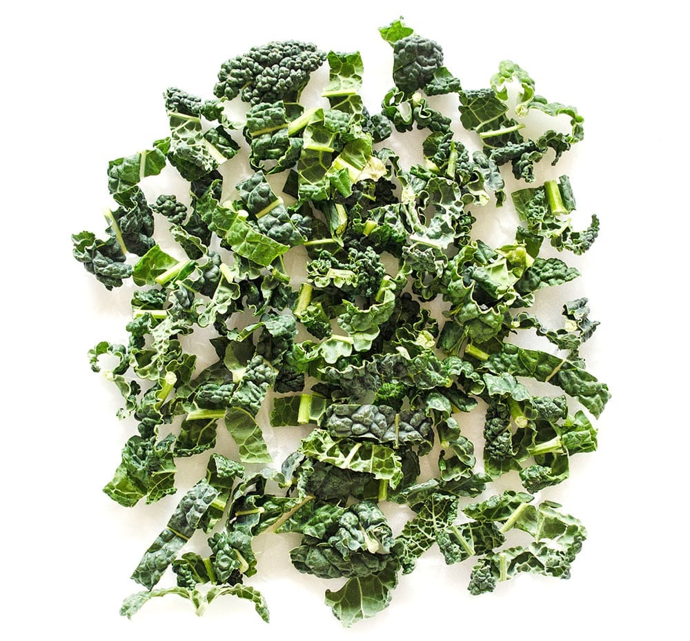 Photo of chipped kale on white background