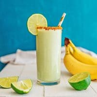 key lime pie smoothie in a glass with a straw