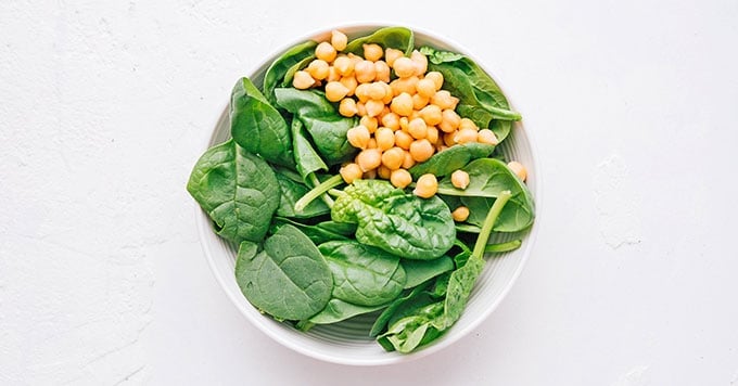 Chickpeas and spinach in a white bowl