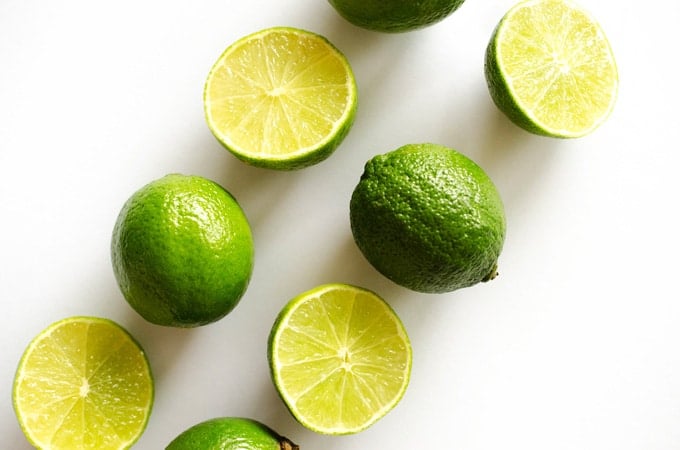 Lime fruits cut in half on a white background
