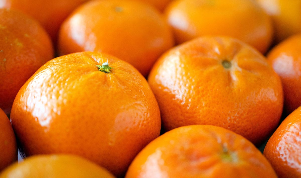 Many mandarin oranges close up.
