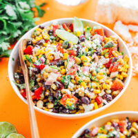Mexican street corn salad in a white bowl with a spoon