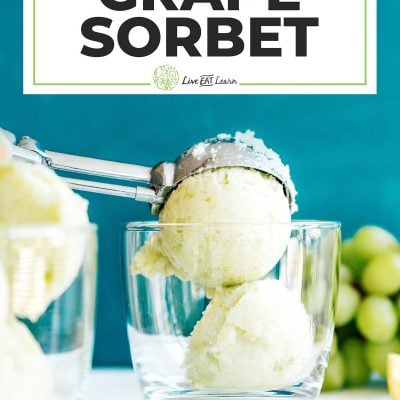 Scoops of green grape sorbet into a glass on a blue background