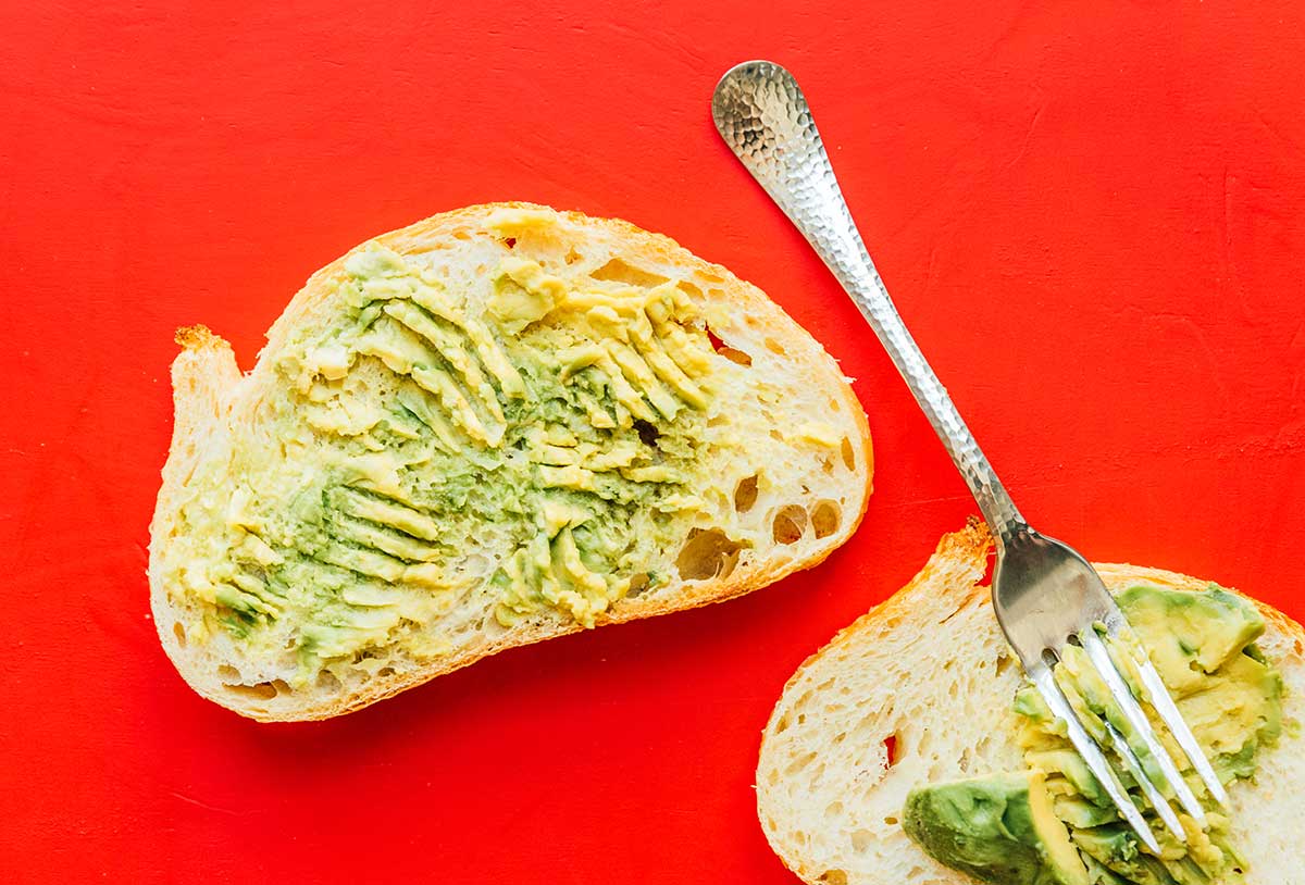 Two slices of sourdough bread with avocado spread on top