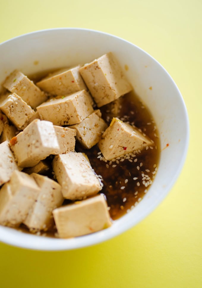 Marinating tofu in a bowl for vegetarian Pineapple Poke Bowls