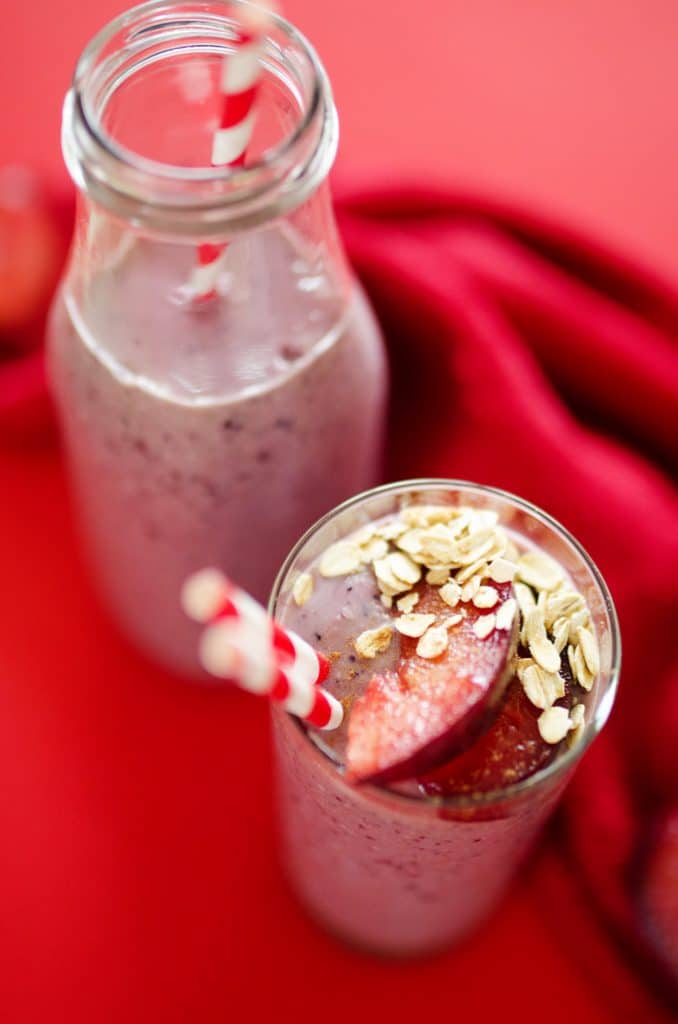 Berry Plum Cobbler Smoothie with oatmeal on top and straws in a glass