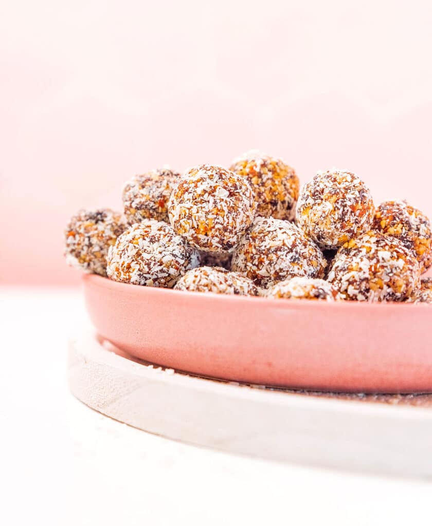 A pink bowl filled with coconut energy bites