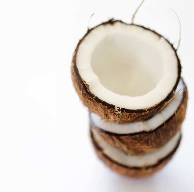 Picture of halved coconut shells on white background