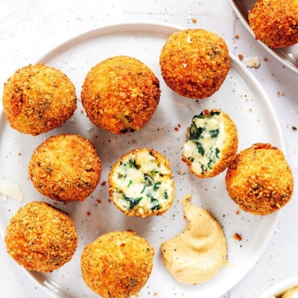 Mashed potato croquettes on a white plate with mustard