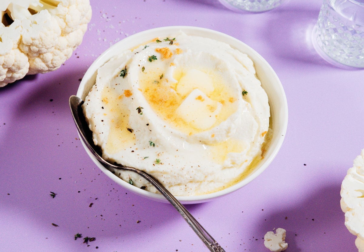 Mashed cauliflower in a bowl with a spoon.