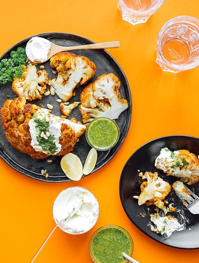 Marinated cauliflower on a plate with herb sauce and whipped feta cheese