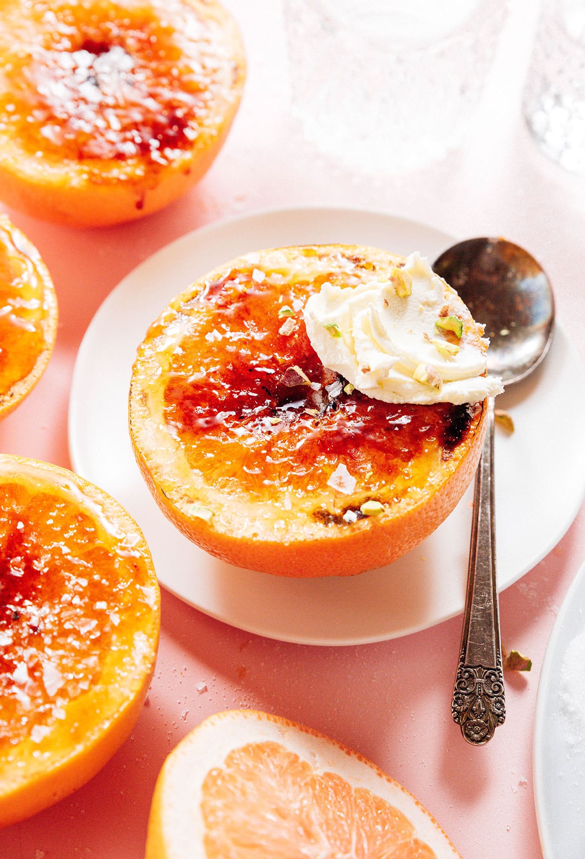 Grapefruit brulee on a plate with a spoon.
