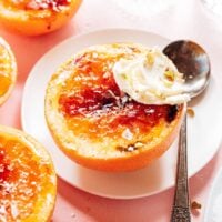 Grapefruit brulee with mascarpone on a plate with a spoon.
