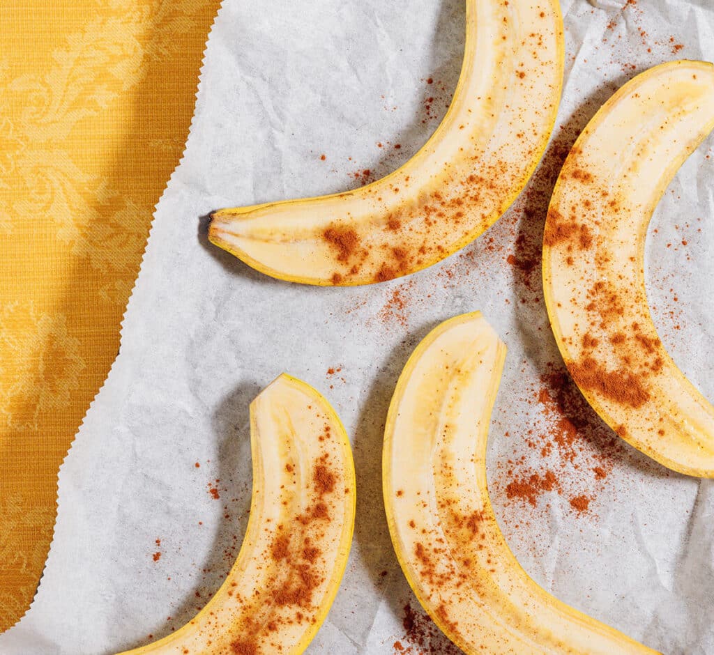 Bananas on a baking sheet with cinnamon.