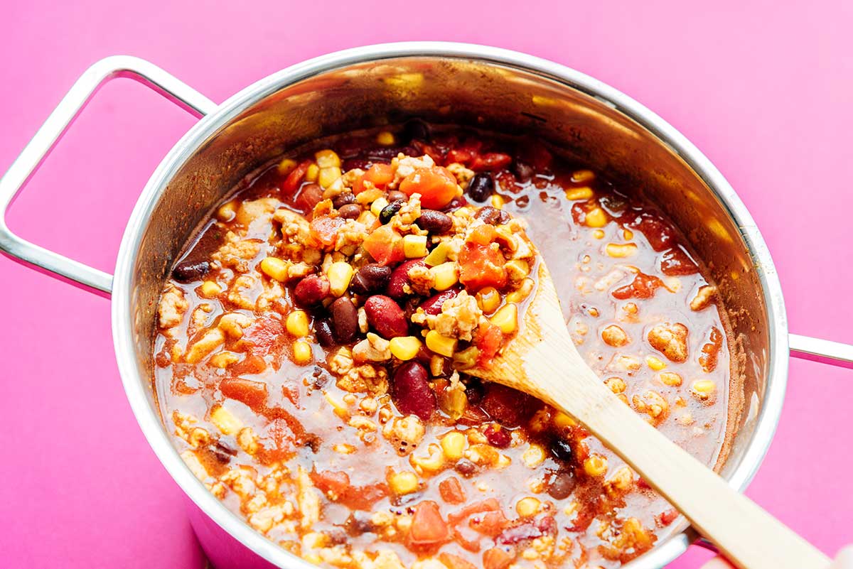 Taco soup in a pan on a pink background
