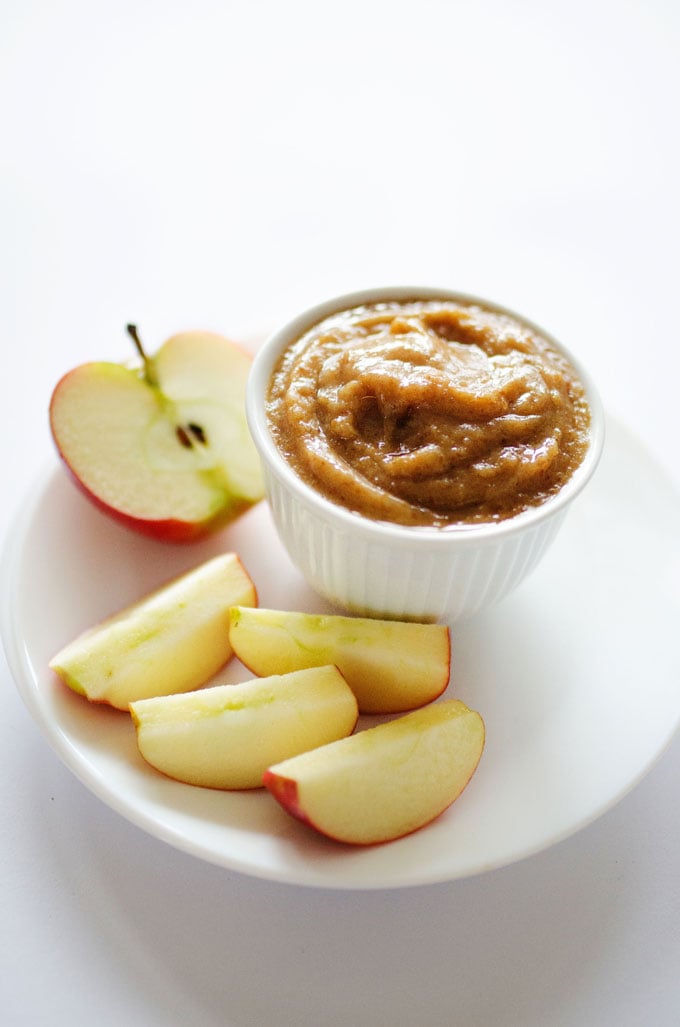 Date caramel in a bowl with apple slices on a white background