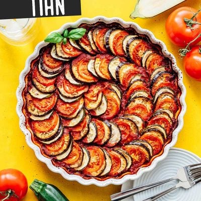 Vegetable tian in a tart pan on a yellow background