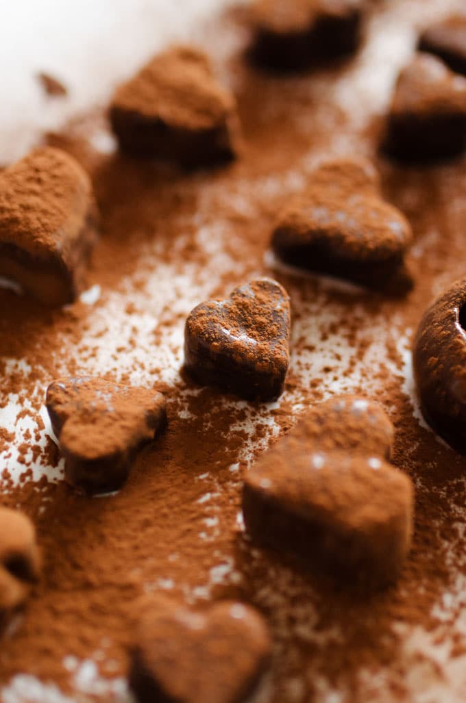 Chocolate fruit truffles shaped like hearts with chocolate powder